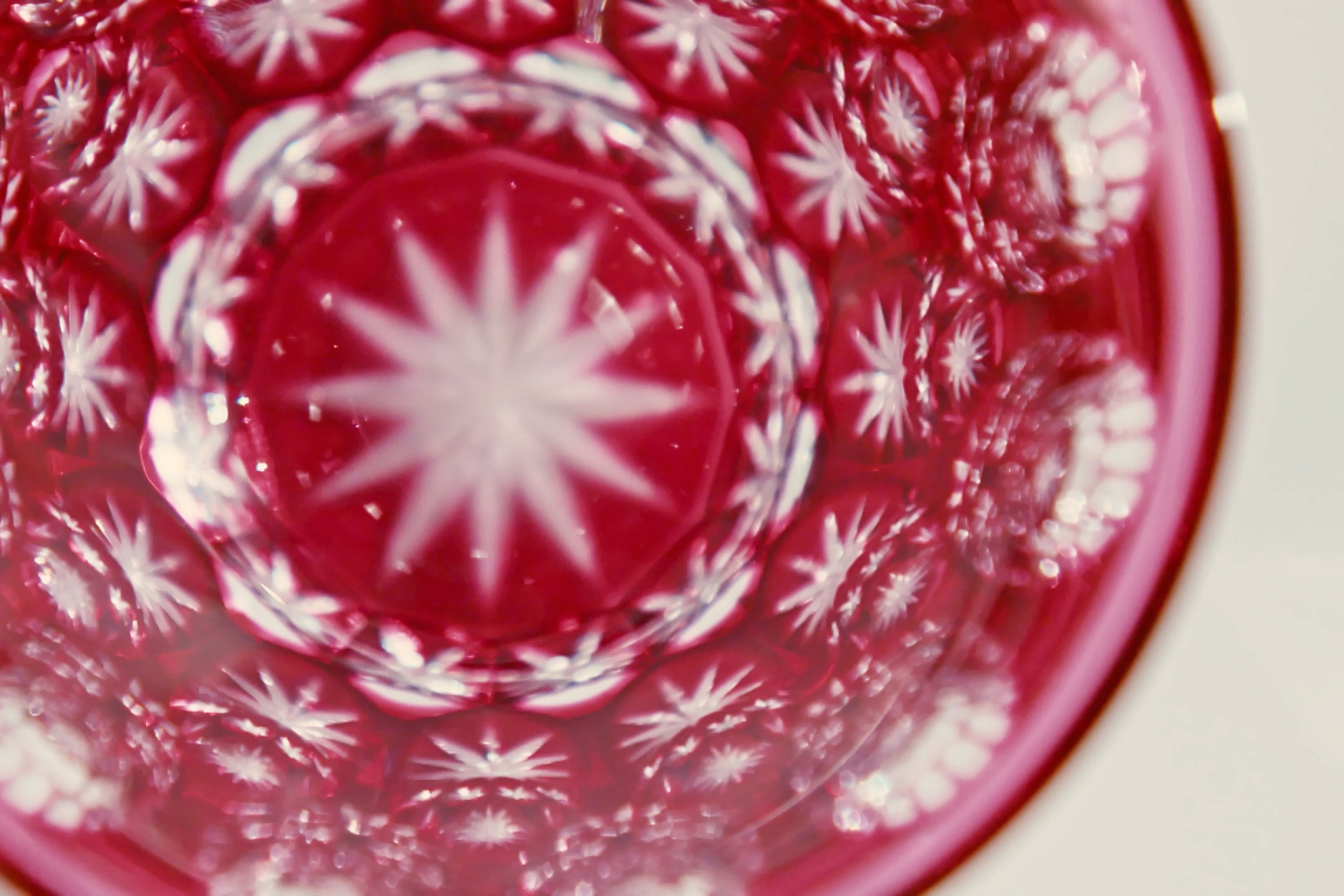 Intricate cut patterns are reflected inside the pink Temma Kiriko glass